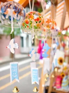 A beautifully hand-painted wind chime hanging by a window, symbolizing peace and good fortune